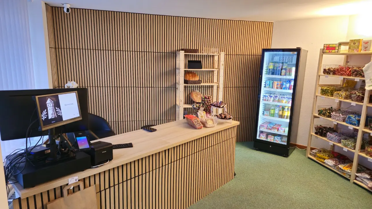 Comptoir d’accueil avec caisse et frigo de boissons